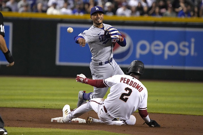 Los Angeles Dodgers second baseman Mookie Betts turns the double play while avoiding Arizona Diamondbacks' Geraldo Perdomo (2) on a ball hit by Carson Kelly in the third inning during a game, Monday, Sept. 12, 2022, in Phoenix. (Rick Scuteri/AP)
