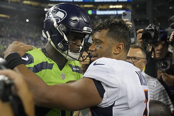 Seattle Seahawks quarterback Geno Smith, left, talks with Denver Broncos quarterback Russell Wilson, right, after a game, Monday, Sept. 12, 2022, in Seattle. The Seahawks won 17-16. (Stephen Brashear/AP)