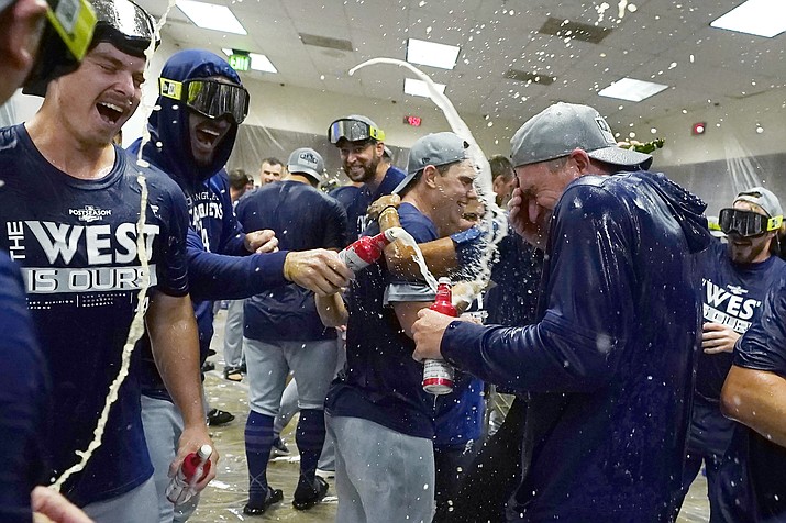 Los Angeles Dodgers celebrate in the locker room after a 4-0 win in a game against the Arizona Diamondbacks in Phoenix, Tuesday, Sept. 13, 2022. The Dodgers clinched the National League West. (Ross D. Franklin/AP)
