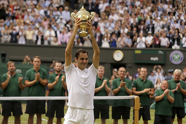 Switzerland’s Roger Federer is applauded by ground staff as he holds the trophy after defeating Croatia’s Marin Cilic to win the Men’s Singles final match on Day 13 at the Wimbledon Championships in London Sunday, July 16, 2017. (Alastair Grant/AP, file)