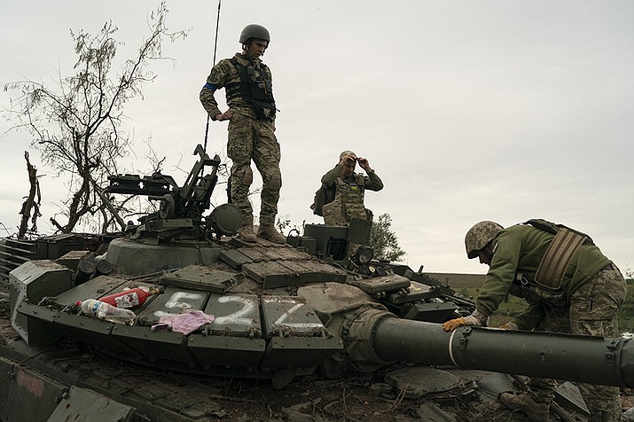 Ukrainian servicemen stand atop a destroyed Russian tank in a retaken area near the border with Russia in Kharkiv region, Ukraine, Saturday, Sept. 17, 2022. (Leo Correa/AP)