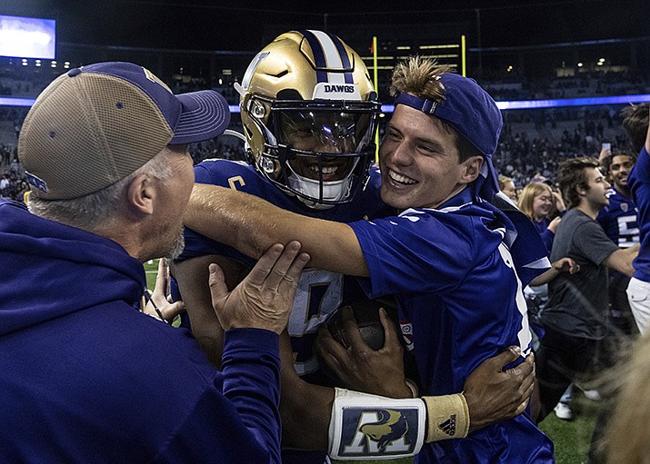 Fans celebrate with Washington quarterback Michael Penix Jr., center, after an NCAA college football game against Michigan State, Saturday, Sept. 17, 2022, in Seattle. (Stephen Brashear/AP)