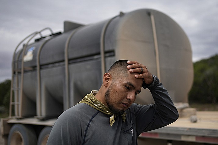 Garnett Querta wipes sweat from his head while hauling water on the Hualapai reservation. The water pulled from the ground will be piped to Grand Canyon West. (AP Photo/John Locher)