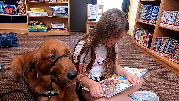 Ana Trombetta, 8, reads to Cooper, a therapy dog, at the Chino Valley Children’s Library, on Thursday, Sept. 15, 2022. (Jesse Bertel/Review)