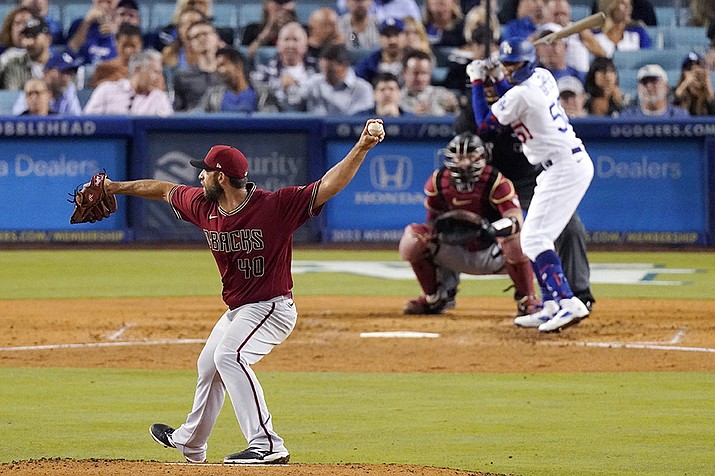 Arizona Diamondbacks starting pitcher Madison Bumgarner, left, pitches to Los Angeles Dodgers' Mookie Betts, right, as catcher Carson Kelly is behind the plate during the sixth inning Wednesday, Sept. 21, 2022, in Los Angeles. (Mark J. Terrill/AP)