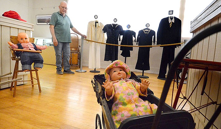 Kelly Sommers, director of the Clemenceau Heritage Museum, shows some of the delicate uniforms, clothing and dolls that can be affected by humidity and hot weather. (VVN/Vyto Starinskas)