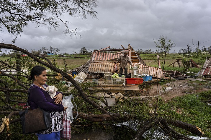 Mercedes Valdez holds her dog Kira as she waits for transportation after losing her home to Hurricane Ian in Pinar del Rio, Cuba, Tuesday, Sept. 27, 2022. (Ramon Espinosa/AP)