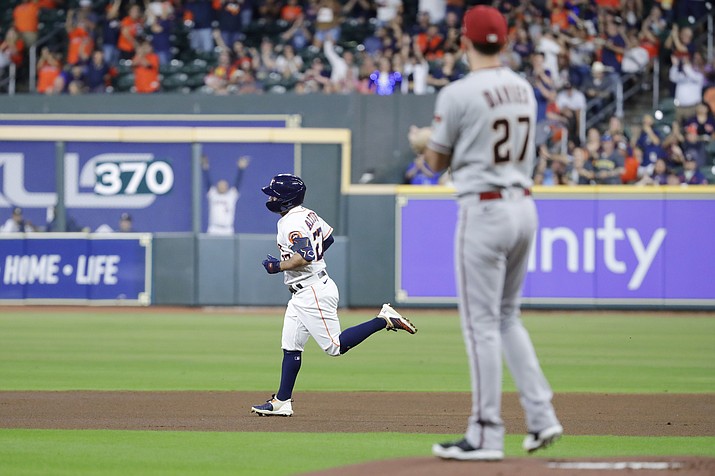 Houston Astros' Jose Altuve, left, heads to second base on his home run off of Arizona Diamondbacks starting pitcher Zach Davies (27), as he looks on from the mound during the first inning of a baseball game Tuesday, Sept. 27, 2022, in Houston. (Michael Wyke/AP)