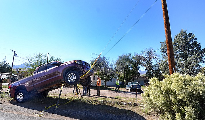 Police wait for a tow truck to carefully remove a pickup from a metal guy-wire of a power pole on Friday, Oct 28, 2022. (VVN/Vyto Starinskas)
