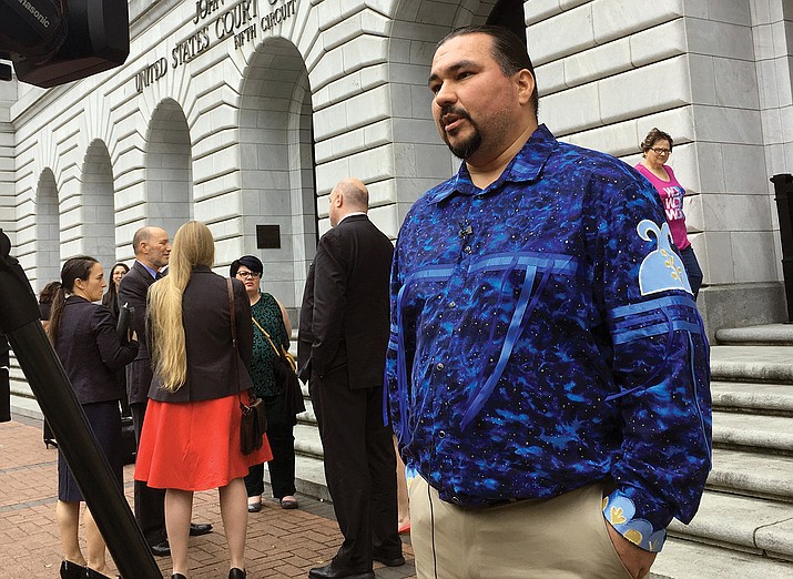 Tehassi Hill, tribal chairman of the Oneida Nation, stands outside a federal appeals court in New Orleans, following arguments on the constitutionality of a 1978 law giving Native American families preference in adoption of Native American children. (AP Photo/Kevin McGill, File)