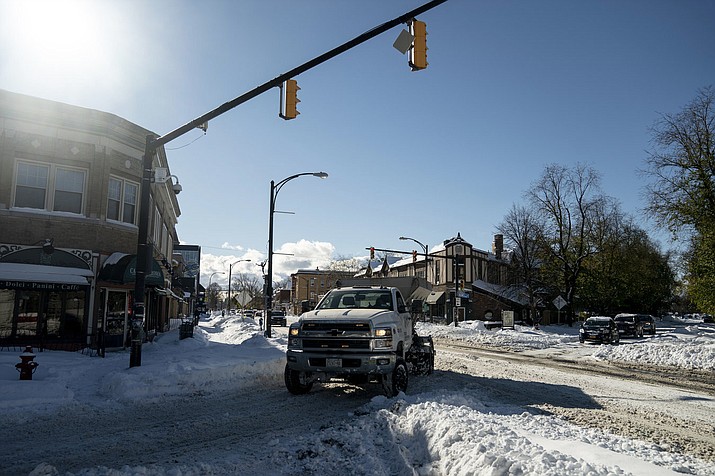 A truck makes a turn at an intersection in the Elmwood neighborhood of Buffalo, N.Y., Sunday, Nov. 20, 2022. Many side streets remained uncleared after two days of lake-effect snow. (Libby March/The Buffalo News via AP)