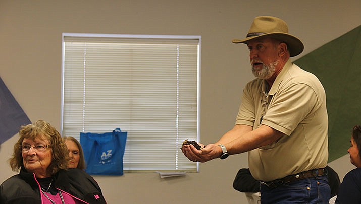 Instructor Zen Mocarski shows off compost mix to attendees at a gardening lecture at the New Life Church in Kingman on Nov. 19. (Photo by William Roller/Kingman Miner)