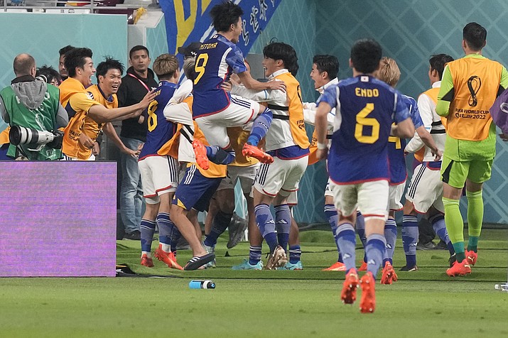 Japan players celebrate after Takuma Asano scored his side's second goal during the World Cup group E match between Germany and Japan, at the Khalifa International Stadium in Doha, Qatar, Wednesday, Nov. 23, 2022. (Eugene Hoshiko/AP)