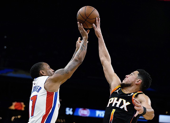 Phoenix Suns' Devin Booker (1) blocks a shot from Detroit Pistons' Rodney McGruder (17) during the first half of an NBA basketball game in Phoenix, Friday, Nov. 25, 2022. (Darryl Webb/AP)