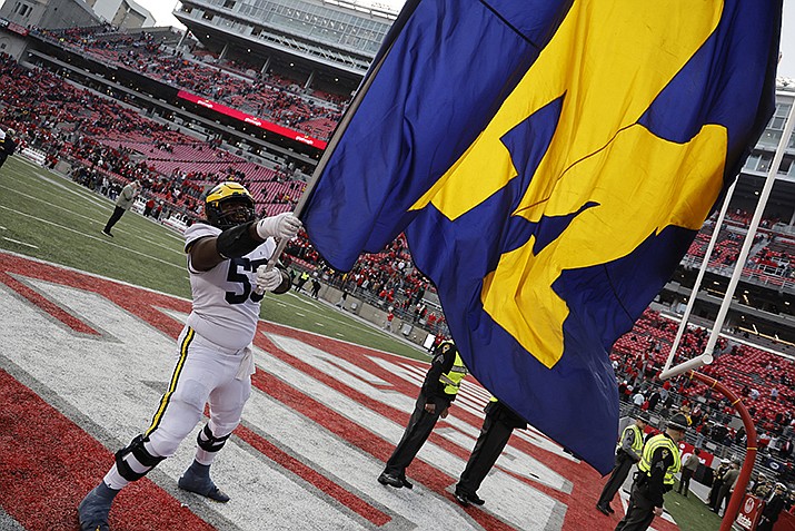 Michigan offensive lineman Trente Jones waves their flag to celebrate their win over Ohio State in an NCAA college football game on Saturday, Nov. 26, 2022, in Columbus, Ohio. (Jay LaPrete/AP)