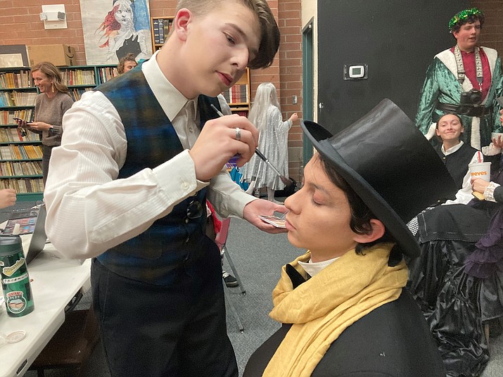 Prescott High School “A Christmas Carol” theater manager and cast member Connor Ratajski applies makeup for a senior star of the show, Zakary Dennen, who is performing as Ebeneezer Scrooge in the Charles Dickens holiday classic. (Nanci Hutson/Courier)