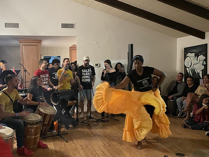 Aurelia Rascon of Orgullo Boricua AZ performs as members of Grupo BombAZo play the drums in a home in north Phoenix on Oct. 15, 2022, at a fundraiser organized by the Puerto Rican Center of Arizona. (Jennifer Sawhney/Cronkite News)