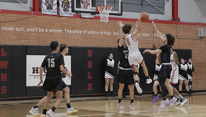 Alex Stout of Lee Williams High School attempts a pass while surrounded by Lake Havasu High School Knights’ defenders in the Volunteers 57-48 victory over the Knights on Thursday, Dec. 1. (Photo by Claude Saravia/For the Miner)