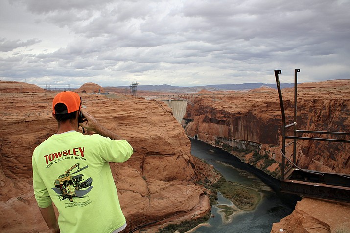 Tobyn Pilot of Page Utility Enterprises looks down toward Glen Canyon Dam. A pipe within the dam pulls water up to the small city of Page, but it needed modifications to keep operating amid dropping levels at Lake Powell. The city says it needs help funding a second pipe that would provide long-term water security. (Alex Hager/KUNC)