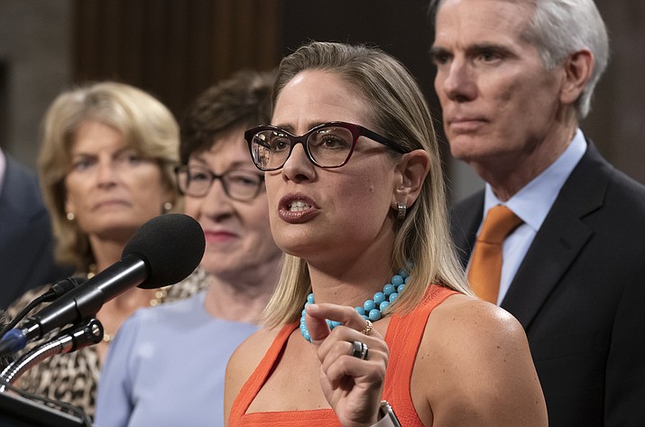Sen. Kyrsten Sinema, D-Ariz., center, gestures during a news conference at the Capitol in Washington, July 28, 2021, while working on a bipartisan infrastructure bill with, from left, Sen. Lisa Murkowski, R-Alaska, Sen. Susan Collins, R-Maine, and Sen. Rob Portman, R-Ohio. Though elected as a Democrat, Sinema announced Friday, Dec. 9, that she has registered as an Independent, but she does not plan to caucus with Republicans, ensuring Democrats will retain their narrow majority in the Senate. (J. Scott Applewhite/AP, File)