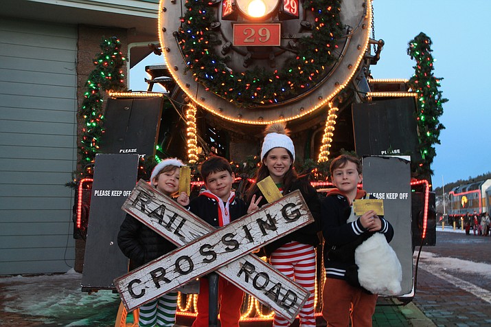 All aboard! Tickets in-hand, children pose in front of a Grand Canyon Railway train as they wait to board the Polar Express and make their excursion to the North Pole. (Summer Serino/WGCN)