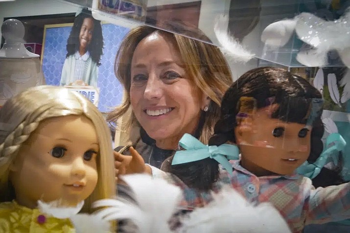 Jamie Cygielman, general manager and president at American Girl, poses behind a showcase of dolls during a press tour, Friday, Dec. 2, 2022, in New York. Cygielman said she first discovered interest from adults for toys of their own after the launch of the 17th historical doll Courtney Moore in late 2020. (Bebeto Matthews/AP)