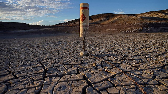 A buoy sits high and dry on cracked earth previously under the waters of Lake Mead at the Lake Mead National Recreation Area near Boulder City, Nev., on June 28, 2022. Living with less water in the U.S. Southwest is the focus for a conference starting Wednesday, Dec. 14, 2022, in Las Vegas, about the drought-stricken and overpromised Colorado River. (AP Photo/John Locher)