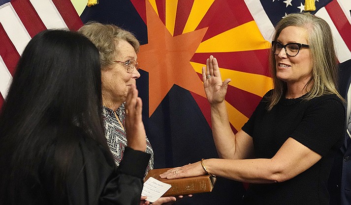 Gov. Katie Hobbs, right, takes the oath of office in a ceremony as U.S. Circuit Judge for the Ninth Circuit Court of Appeals Roopali Desai, left, administers the oath while Hobbs’ mother Linda Hobbs holds the bible at the state Capitol in Phoenix, Monday, Jan. 2, 2023. (AP Photo/Ross D. Franklin, Pool)