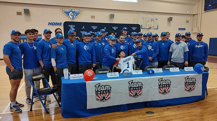 During a brief ceremonial event on Monday, Jan. 9, local boy Eli Sanchez, who was injured in a car crash and left paralyzed from the neck down, signed with the Embry-Riddle Eagles baseball team through an effort by Team IMPACT. Shown in the photo is Sanchez with his jersey, surrounded by the baseball team and coaching staff.(Tom Staples/Courier)