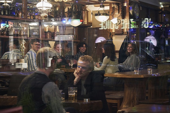 People sit in a bar in Stockholm, Sweden, on March 25, 2020. Sweden wants to cut red tape when it comes to dancing. The Swedish center-right coalition government wants to abolish a decade-old permit requirement, meaning the days of the so-called dance license is doomed. The proposal means that restaurants and nightclubs, among other places, no longer require approval from authorities to organize a dance performance. (David Keyton/AP, File)