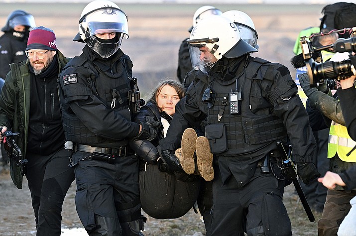 Police officers carry Swedish climate activist Greta Thunberg away from the edge of the Garzweiler II opencast lignite mine during a protest action by climate activists after the clearance of Luetzerath, Germany, Tuesday, Jan. 17, 2023. After the eviction of Luetzerath ended on Sunday, coal opponents continued their protests on Tuesday at several locations in North Rhine-Westphalia. (Federico Gambarini/dpa via AP)