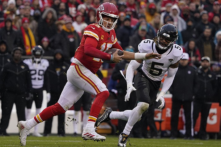 Kansas City Chiefs quarterback Patrick Mahomes (15) runs out of the pocket as Jacksonville Jaguars safety Andre Cisco (5) defends during the first half of an NFL divisional round playoff football game, Saturday, Jan. 21, 2023, in Kansas City, Mo. Mahomes was injured after the play. (AP Photo/Ed Zurga/AP)