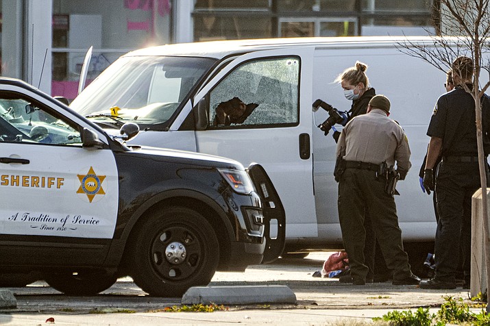 A body is seen on the driver's side of a van as authorities investigate, in Torrance, Calif., Sunday, Jan. 22, 2023. Authorities say the driver, the suspect in a California dance club shooting that left multiple people dead, shot and killed himself. (Damian Dovarganes/AP)