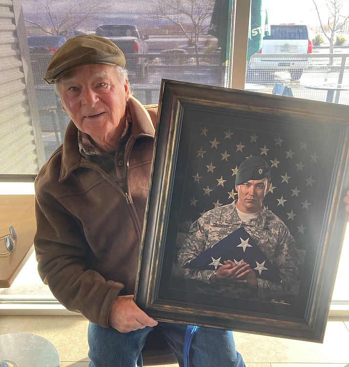 Vision of Vets Founder and photographer Bruce Roscoe shows portrait of U.S. Army Green Beret Sgt. Major Michael Glover, the first veteran to be featured on a new “Wall of Honor” in the Safeway grocery store in Prescott Valley. (Nanci Hutson/Courier)