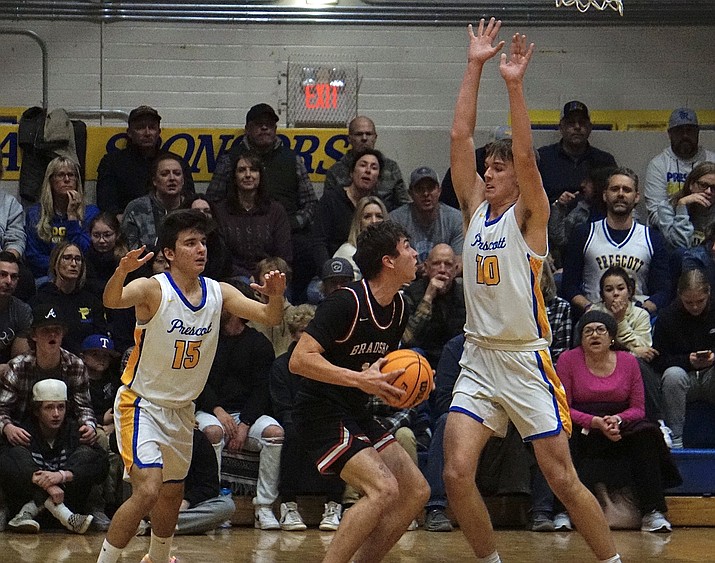 Bradshaw Mountain’s Caden Reed (12) goes up for the shot against Prescott’s Zane Gaul (100 and Andrew Lyon (15) during a game on Thursday, Jan. 26, 2023, at Prescott’s Dome Gym. (Aaron Valdez/Courier)