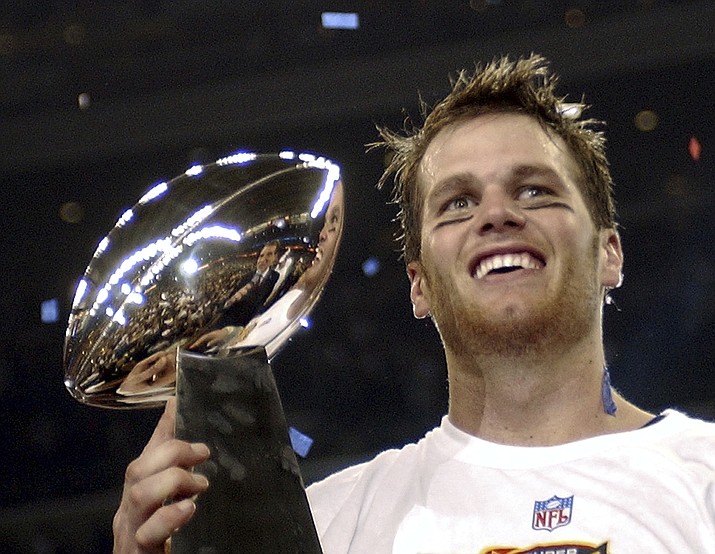 In this Feb. 1, 2004, file photo, New England Patriots quarterback Tom Brady holds the Vince Lombardi Trophy after the Patriots beat the Carolina Panthers 32-29 in Super Bowl 38 in Houston. Brady, who won a record seven Super Bowls for New England and Tampa, has announced his retirement, Wednesday, Feb. 1, 2023. (Dave Martin/AP, File)