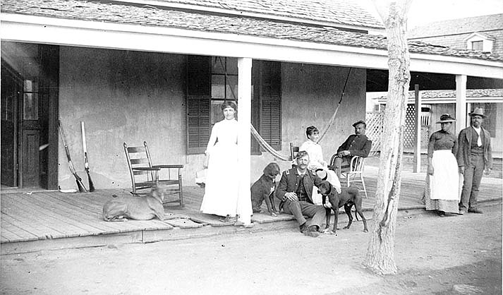 Taken on the front porch of the Bachelor Officers Quarters in the late 1880s.  2nd Lt. William H. Smith is seated in the chair. It is not known who the other people are.  Hunting parties were put together for fun and to bring fresh meat to the table. The dogs were used for hunting. Photo by Dr. Edgar A. Mearns.