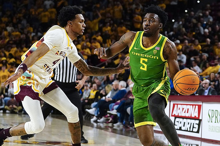 Oregon's Jermaine Couisnard (5) drives around Arizona State's Desmond Cambridge Jr. (4) during the first half of an NCAA college basketball game, Saturday, Feb. 4, 2023, in Tempe. (Darryl Webb/AP)