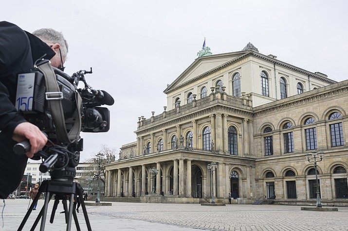 A TV cameraman films the State Opera in Hanover, Germany, Monday, Feb. 13, 2023. A German newspaper critic had animal feces smeared on her face by a ballet director in the city of Hannover after he apparently accused her of driving away ticket holders. The Hannover state theater apologized for the incident on Saturday and said Monday that it was suspending ballet director Marco Goecke with immediate effect. (Julian Stratenschulte/dpa via AP)