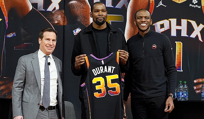 Phoenix Suns forward Kevin Durant, center, holds his jersey after being introduced during an NBA basketball team availability by owner Mat Ishbia, left, and general manager James Jones, Thursday, Feb. 16, 2023, in Phoenix. (AP Photo/Matt York)