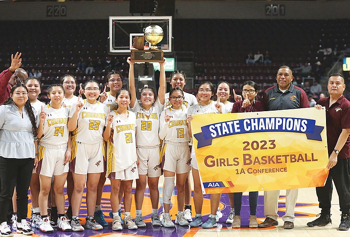 Rock Point's Arianne Begay holds up the 1A state title trophy after the team’s 49-45 win over Joseph City Feb. 18. The Lady Cougars collected their third state championship win. (Marilyn R. Sheldon/NHO)