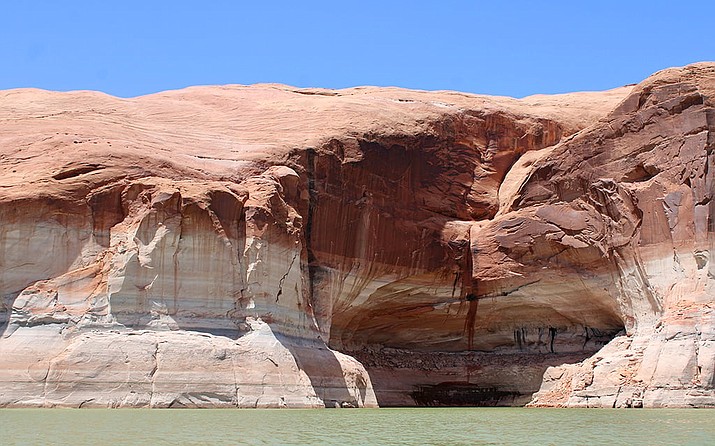 Dropping water levels in Lake Powell have left the familiar “bathtub rings” on the walls of Glen Canyon. Receding water leaves white mineral deposits on the rock, marking the reservoir’s steady retreat. (Alex Hager/KUNC)