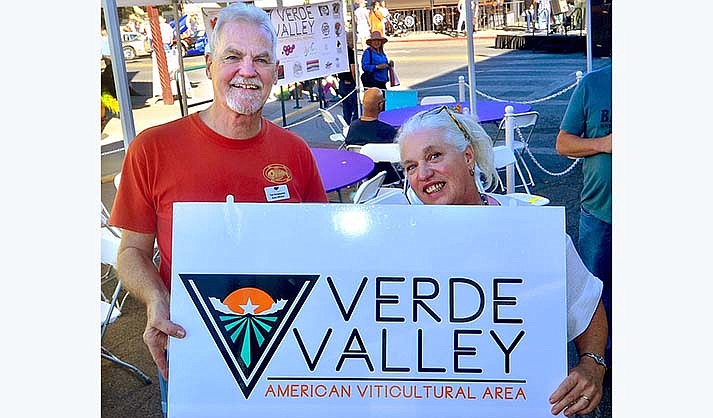 Verde Valley Wine Consortium Immediate Past President Tom Schumacher and the new president, Paula Woolsey, display the new Verde Valley AVA logo at the Walking on Main on Saturday, Nov. 13, 2021. (Vyto Starinskas/Independent, file)