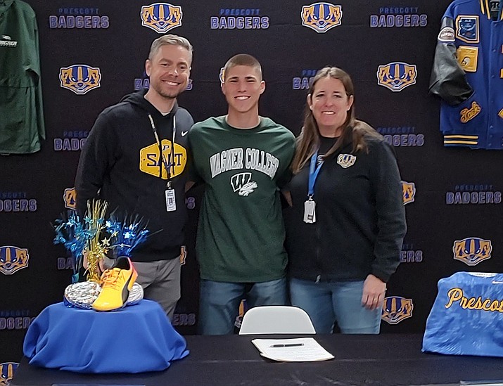 Prescott track & field athlete Jack Mason, center, stands with Principal Adam Neely, left, and Athletic Director Missy Townsend after signing his letter of intent to Wagner College on Friday, March 10, 2023, at the high school library. (Thomas Staples/Courier)