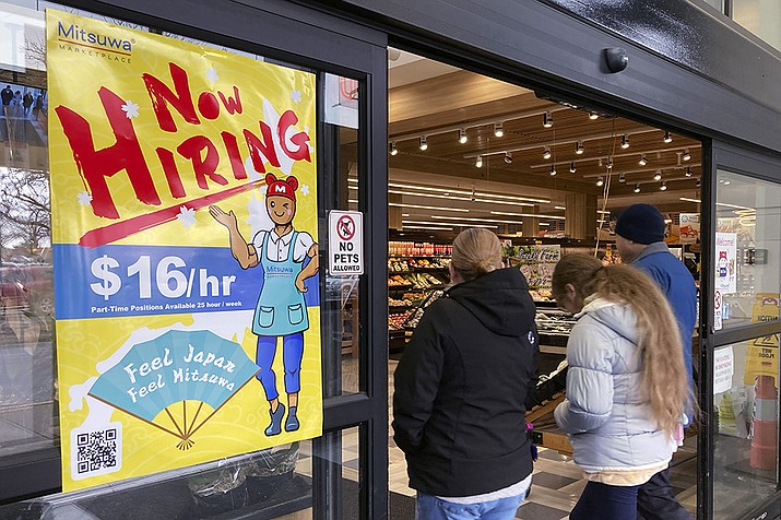 A hiring sign is displayed at a grocery store in Arlington Heights, Ill., Friday, Jan. 13, 2023. A strong job market has helped fuel the inflation pressures that have led the Federal Reserve to keep raising interest rates. (Nam Y. Huh, AP File)