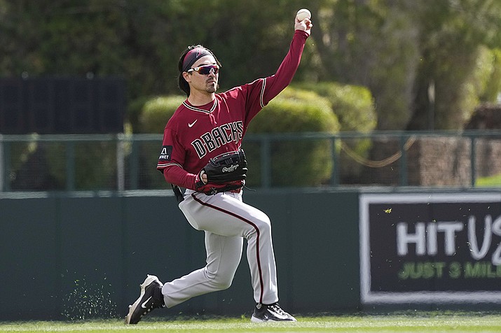 Arizona Diamondbacks left fielder Corbin Carroll throws the ball back to the infield after making a catch on a fly ball hit by Los Angeles Dodgers' J.D. Martinez during the second inning of a spring training baseball game Thursday, March 2, 2023, in Phoenix. (Ross D. Franklin/AP)