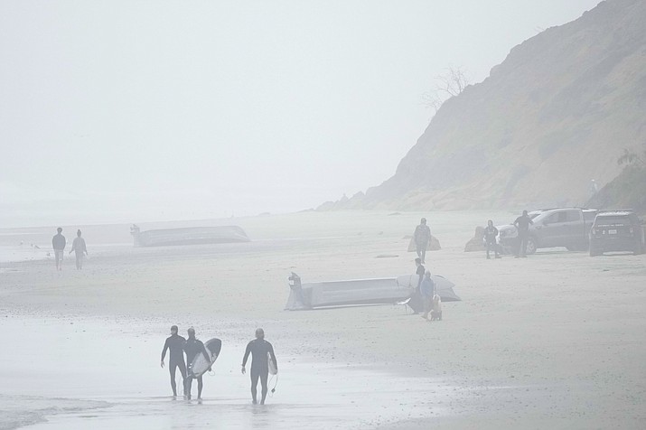 Two boats, one overturned, sit on Blacks Beach, Sunday, March 12, 2023, in San Diego. Authorities say multiple people were killed when two suspected smuggling boats overturned off the coast San Diego, and crews were searching for other victims. (Gregory Bull/AP)