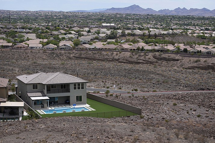 A home with a swimming pool abuts the desert on the edge of the Las Vegas valley July 20, 2022, in Henderson, Nev. Nevada lawmakers on March 13, will consider another shift in water use for one of the driest major metropolitan areas in the U.S. The water agency that manages the Colorado River supply for Vegas is seeking authority to limit what comes out of residents' taps. (AP Photo/John Locher, File)