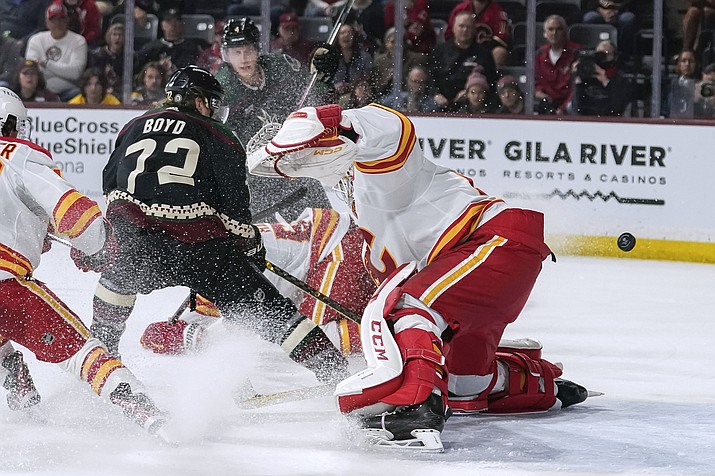 Arizona Coyotes' Travis Boyd (72) slaps the puck past Calgary Flames goalie Jacob Markstrom (25) for an overtime goal iln a game Tuesday, March 14, 2023, in Tempe, Ariz. (Darryl Webb/AP)