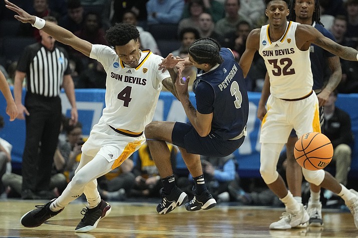 Arizona State's Desmond Cambridge Jr. (4) and Nevada's Trey Pettigrew (3) go for a loose ball during the first half of a First Four game in the NCAA men's basketball tournament, Wednesday, March 15, 2023, in Dayton, Ohio. (AP Photo/Darron Cummings)